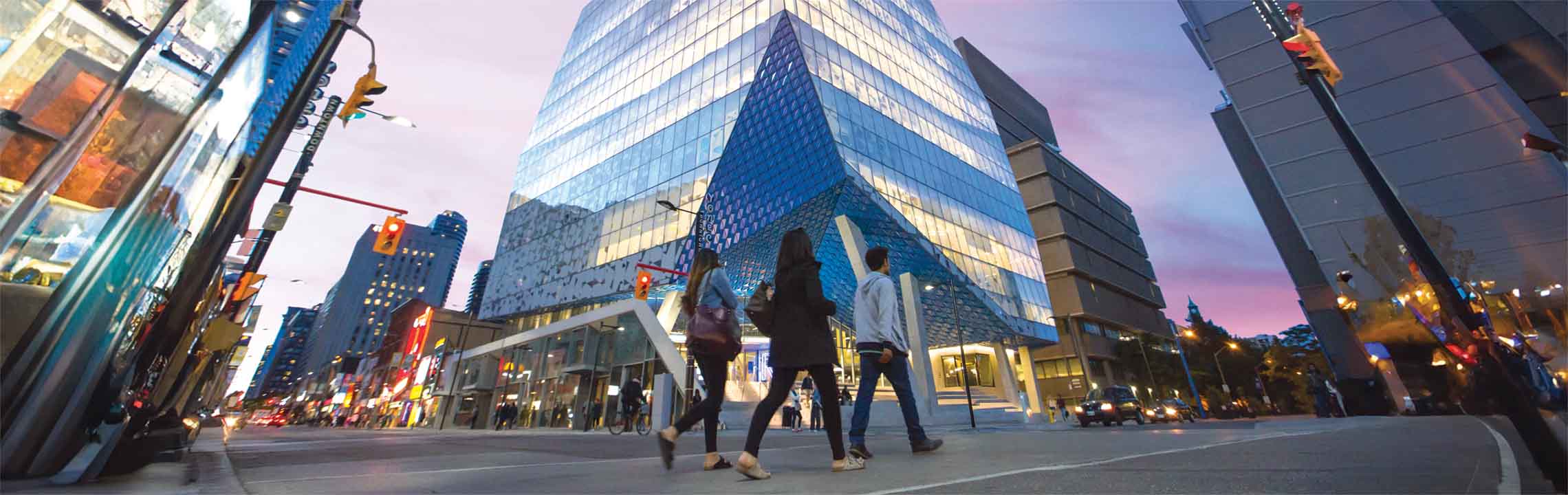 Three students walking across the street in front the Student Life Centre.