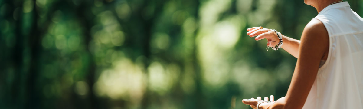 A person practicing with their arms outstretched, moving their body as they breathe.