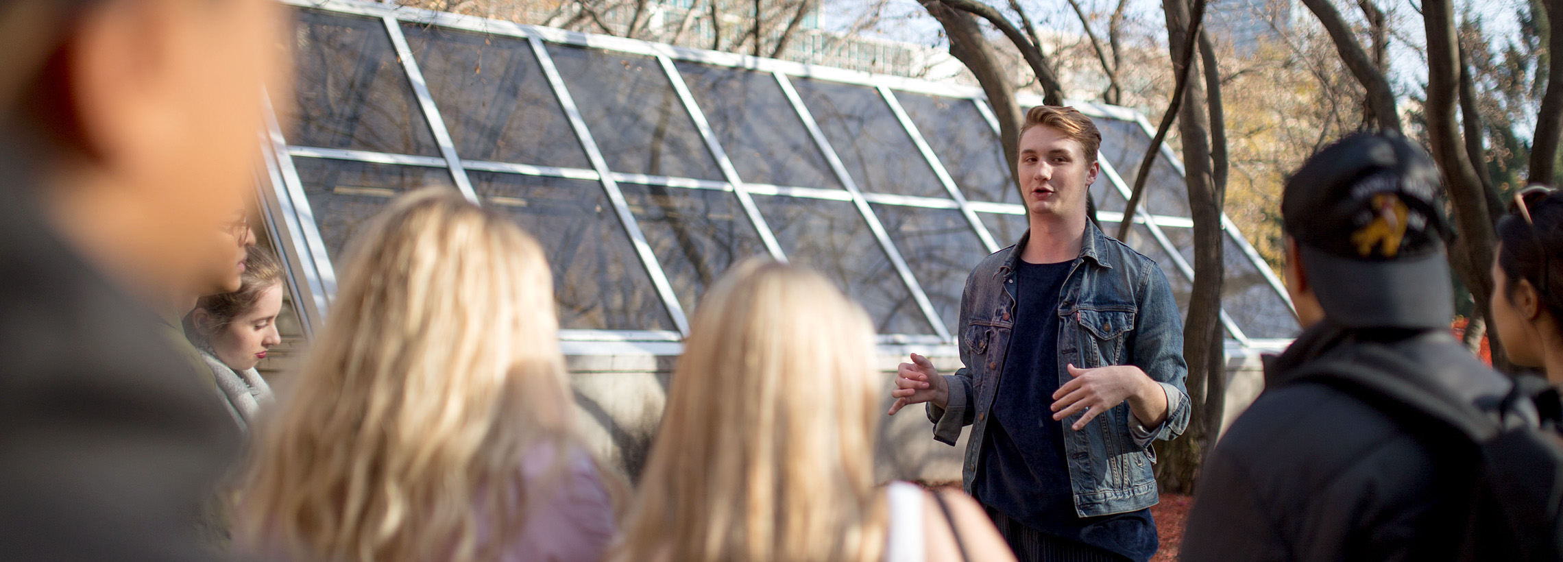 A student tour guide speaking at the Quad to guests touring the TMU campus.