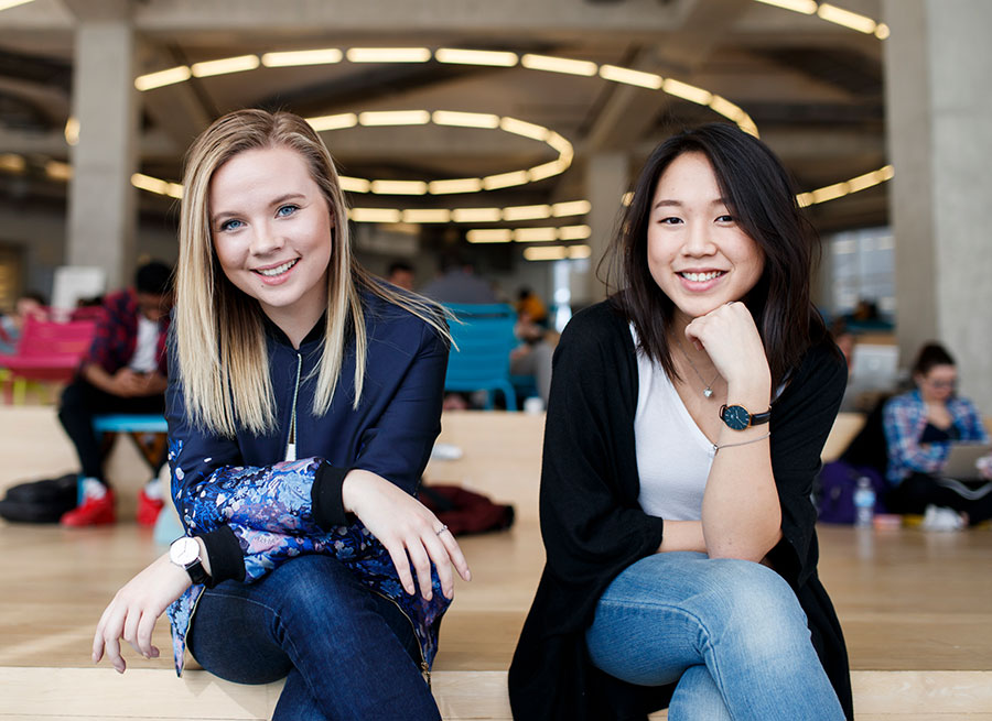 Two students sit on the 6th floor of the SLC.