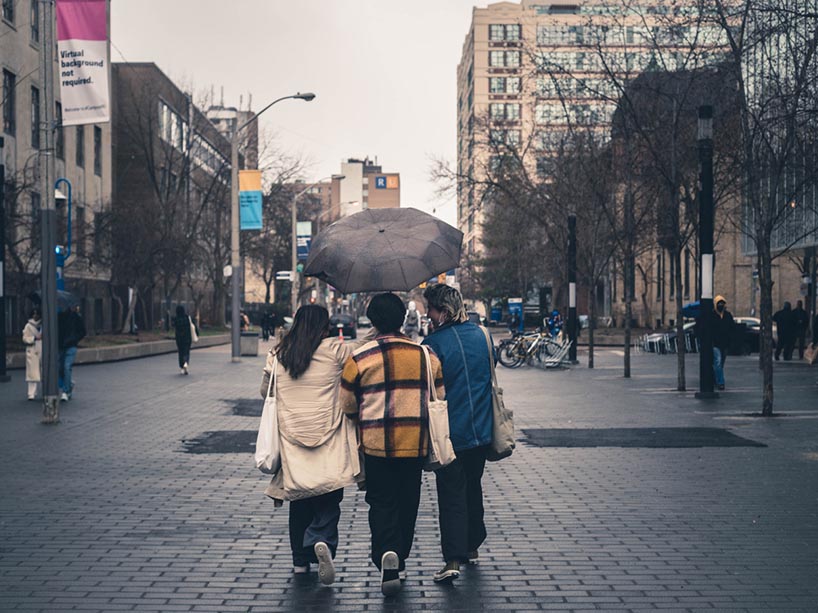 Three students walking on campus together.