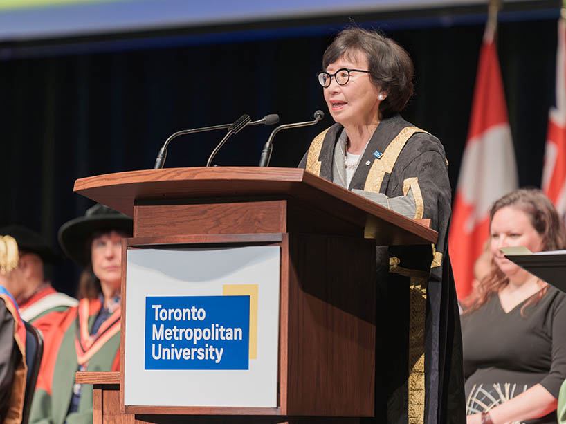 Chancellor Fukakusa speaking at a podium.