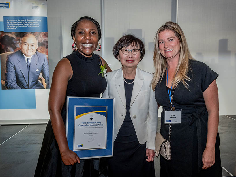 Chancellor Fukakusa stands with an award recipient (left), and TMU administrator (right).